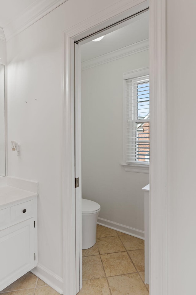 bathroom with ornamental molding, vanity, and toilet