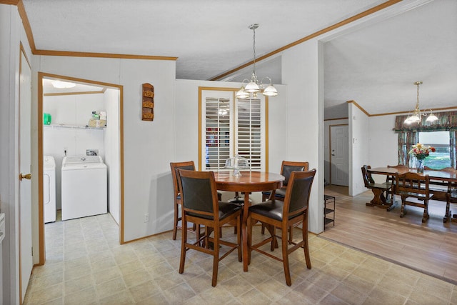 dining room featuring light wood-type flooring, independent washer and dryer, ornamental molding, and an inviting chandelier