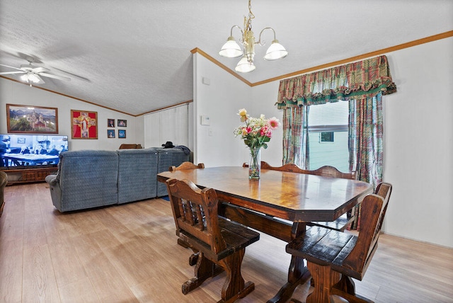 dining area with lofted ceiling, ceiling fan with notable chandelier, crown molding, light hardwood / wood-style flooring, and a textured ceiling