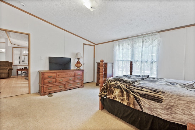 bedroom with lofted ceiling, a textured ceiling, and light carpet