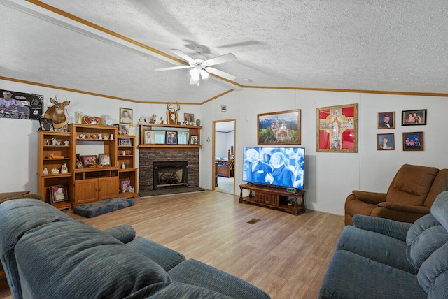 living room featuring ornamental molding, a textured ceiling, ceiling fan, light hardwood / wood-style flooring, and lofted ceiling