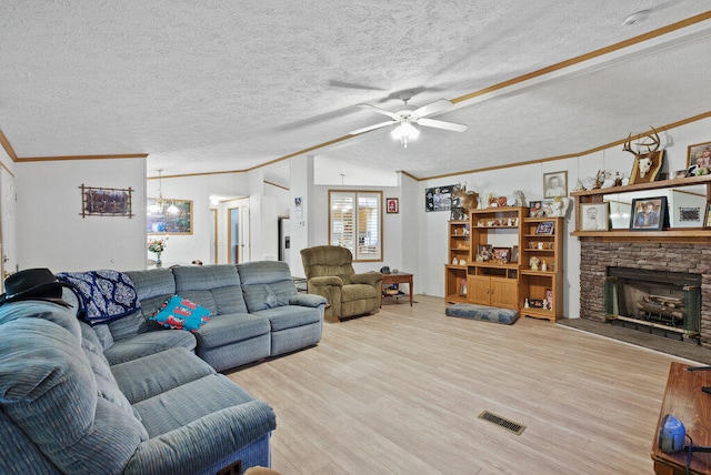 living room featuring light hardwood / wood-style floors, ornamental molding, a textured ceiling, and vaulted ceiling