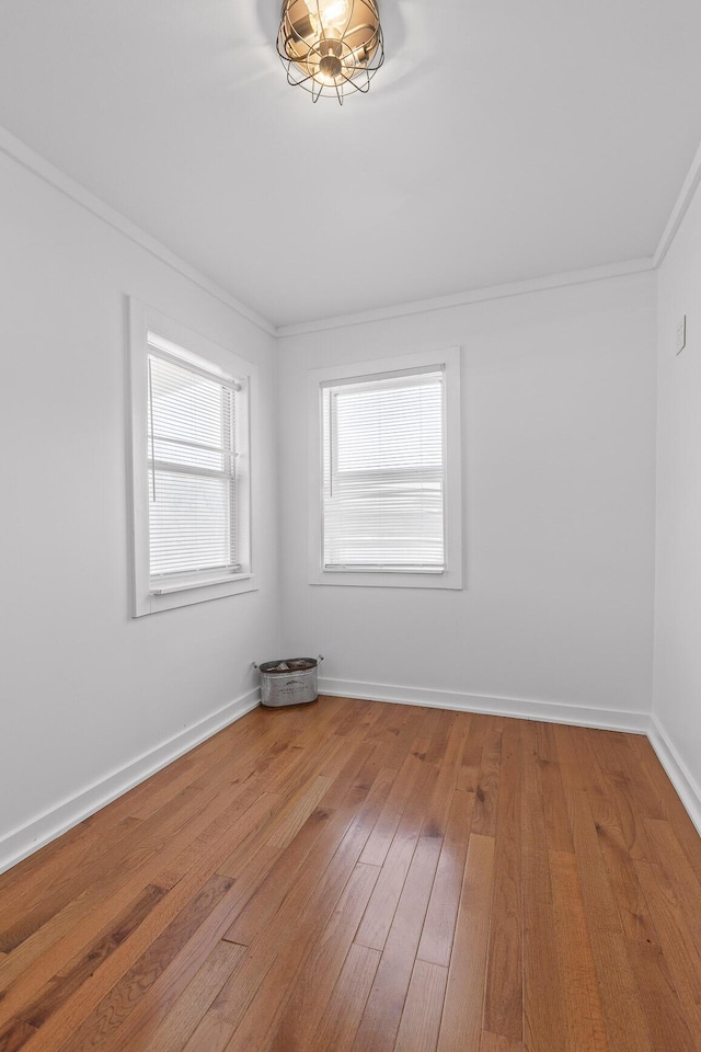 unfurnished room with hardwood / wood-style flooring and crown molding