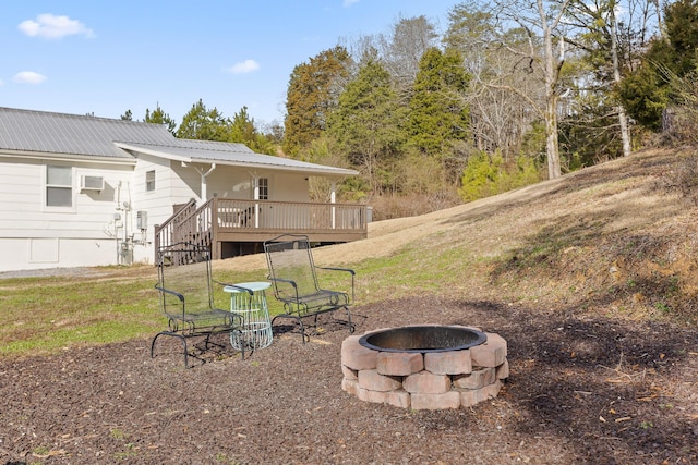 view of yard featuring a wooden deck and a fire pit