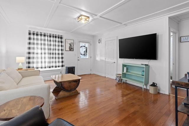 living room with hardwood / wood-style floors, coffered ceiling, and ornamental molding