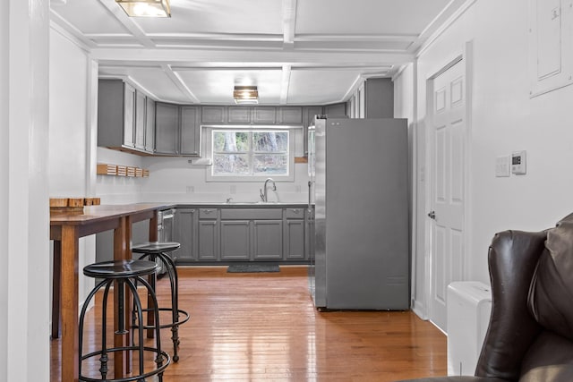 kitchen featuring sink, gray cabinets, stainless steel refrigerator, and light hardwood / wood-style flooring