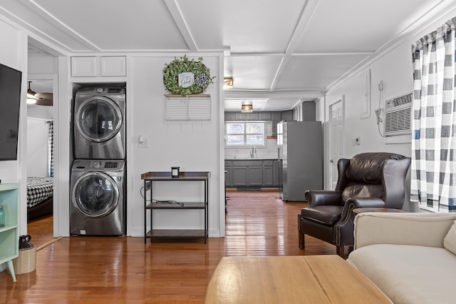 interior space featuring stacked washer and clothes dryer, dark wood-type flooring, and a wall unit AC