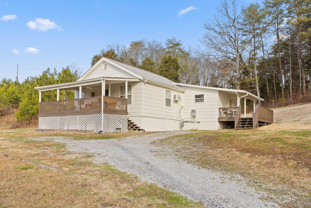 view of front of house featuring an AC wall unit and a porch