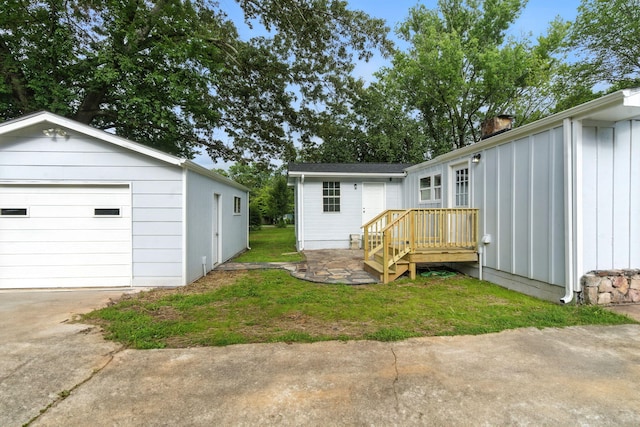 2207 Spencer Ave, Chattanooga, TN 37421 - back of property with a garage, concrete driveway, an outbuilding, a chimney, and a lawn