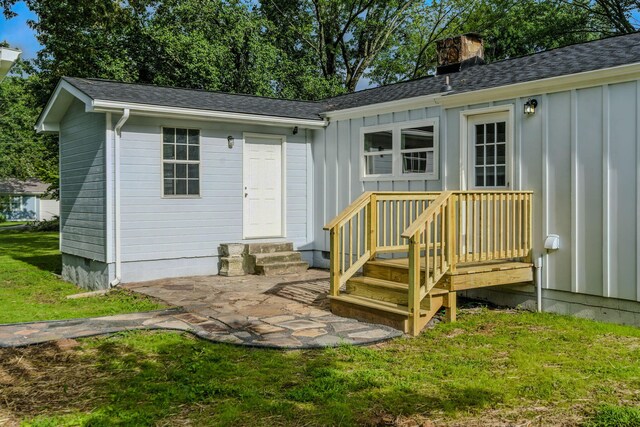 2207 Spencer Ave, Chattanooga, TN 37421 - back of property featuring board and batten siding, a chimney, a shingled roof, and a lawn
