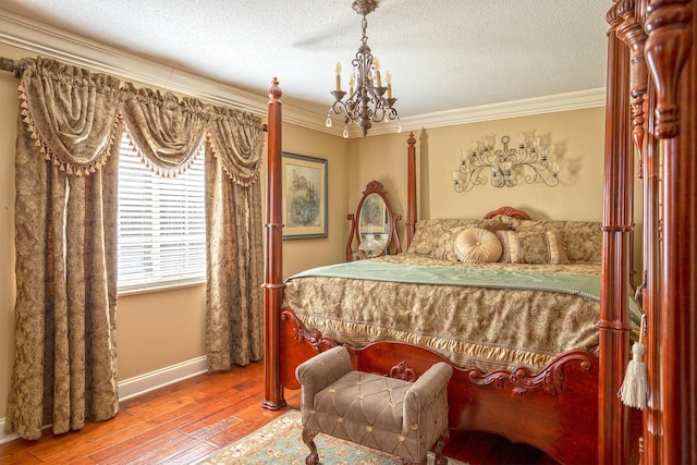 bedroom with a chandelier, wood-type flooring, a textured ceiling, and ornamental molding