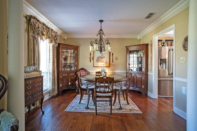 dining space featuring a textured ceiling, dark wood-type flooring, and ornamental molding