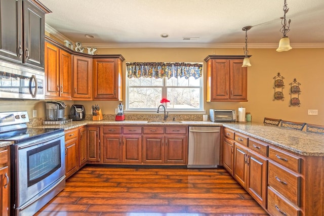 kitchen with appliances with stainless steel finishes, ornamental molding, dark wood-type flooring, sink, and hanging light fixtures