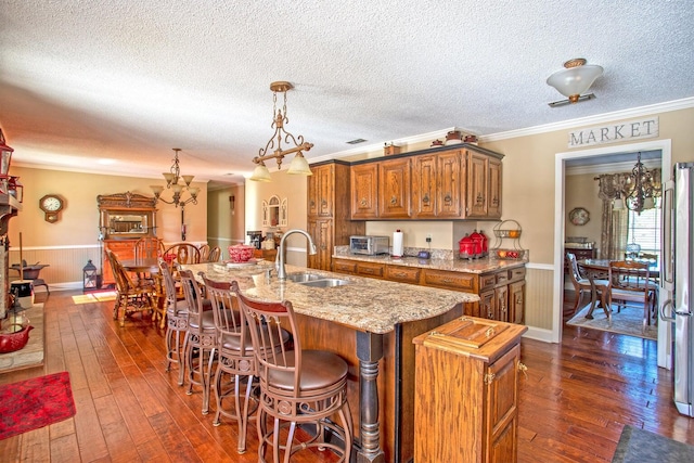 kitchen featuring dark hardwood / wood-style flooring, sink, a textured ceiling, and ornamental molding