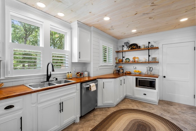 kitchen with wooden counters, appliances with stainless steel finishes, white cabinetry, and sink