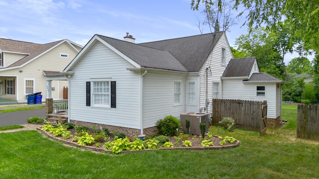 view of side of property featuring a yard and central AC unit