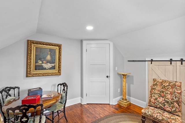 interior space featuring a barn door, hardwood / wood-style flooring, and lofted ceiling