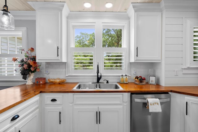 kitchen with white cabinetry, sink, wood counters, stainless steel dishwasher, and decorative backsplash