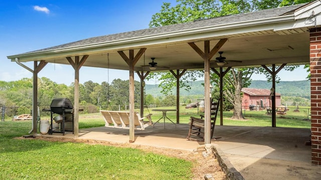 view of property's community with a patio area, a mountain view, and a yard