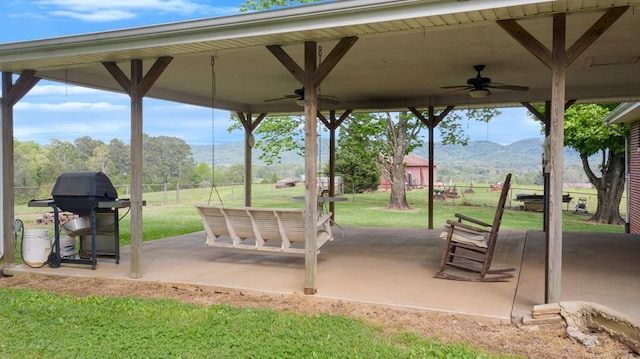 view of property's community featuring a mountain view, a yard, and a patio