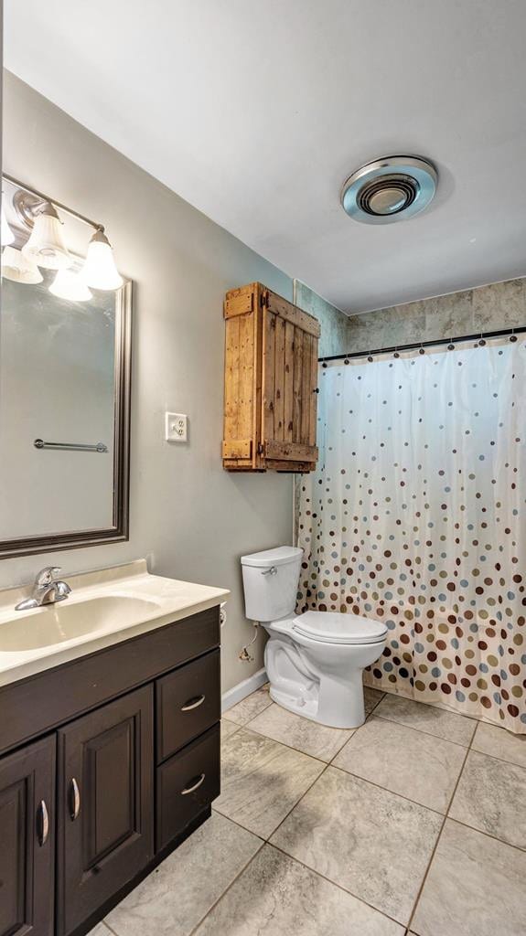 bathroom featuring a shower with curtain, vanity, toilet, and tile patterned floors