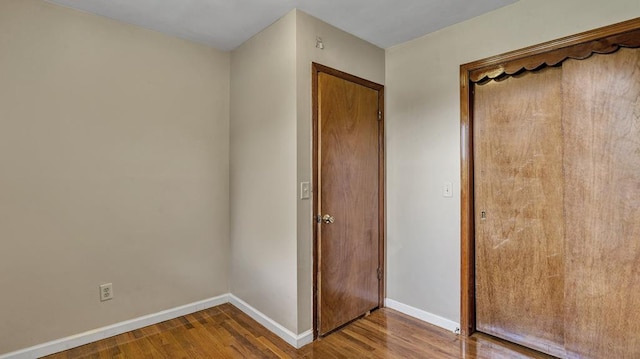 unfurnished bedroom featuring wood-type flooring and a closet