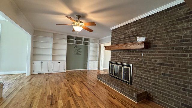 3619 Sourwood Trl, Cleveland, TN 37312 - unfurnished living room featuring ornamental molding, a ceiling fan, a brick fireplace, light wood-style flooring, and built in shelves