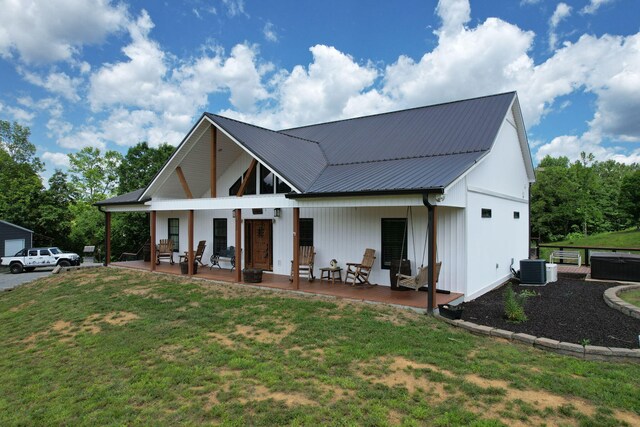 view of front of property featuring a front lawn, cooling unit, and a patio area