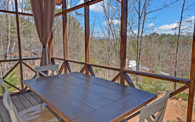 101 Hideaway Trl, Copperhill, TN 37317 - unfurnished sunroom featuring a view of trees, a healthy amount of sunlight, and outdoor dining space