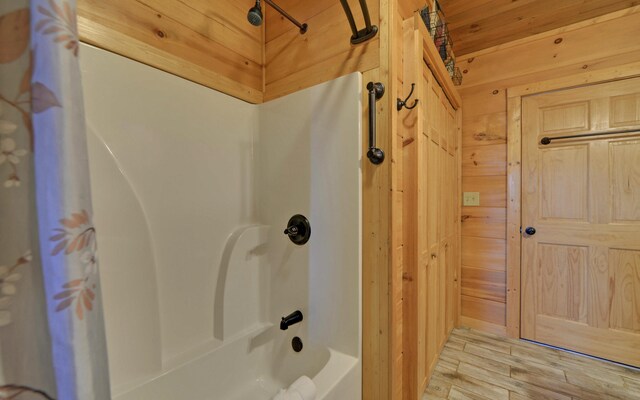 101 Hideaway Trl, Copperhill, TN 37317 - full bath with wood walls, shower / tub combo with curtain, and wood finished floors
