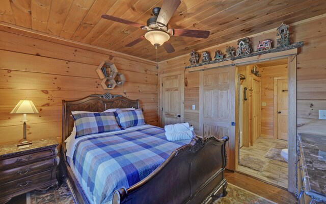 101 Hideaway Trl, Copperhill, TN 37317 - bedroom with ceiling fan, wood walls, a barn door, wooden ceiling, and wood finished floors