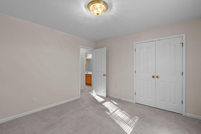 unfurnished bedroom featuring light colored carpet and a closet