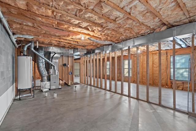 basement featuring gas water heater, heating unit, and plenty of natural light