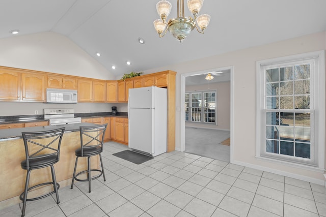 kitchen with white appliances, light tile patterned floors, a kitchen breakfast bar, pendant lighting, and lofted ceiling