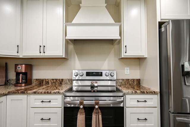 kitchen with stainless steel appliances, white cabinetry, and premium range hood