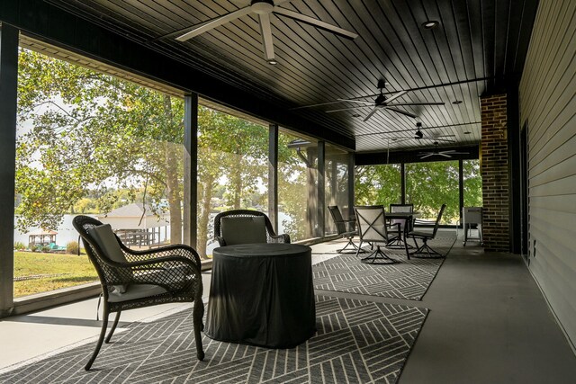 sunroom featuring wooden ceiling, ceiling fan, and a healthy amount of sunlight