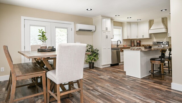 dining area featuring an AC wall unit and dark wood-type flooring