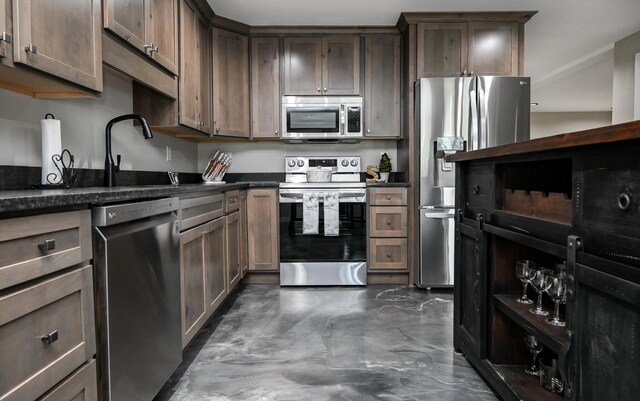 kitchen with dark brown cabinetry and appliances with stainless steel finishes