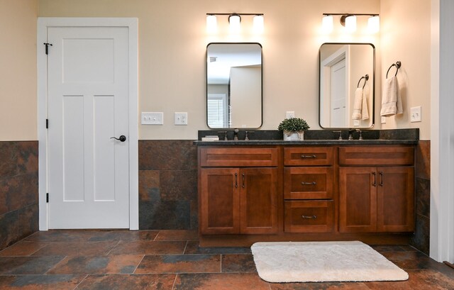 bathroom featuring vanity and tile walls