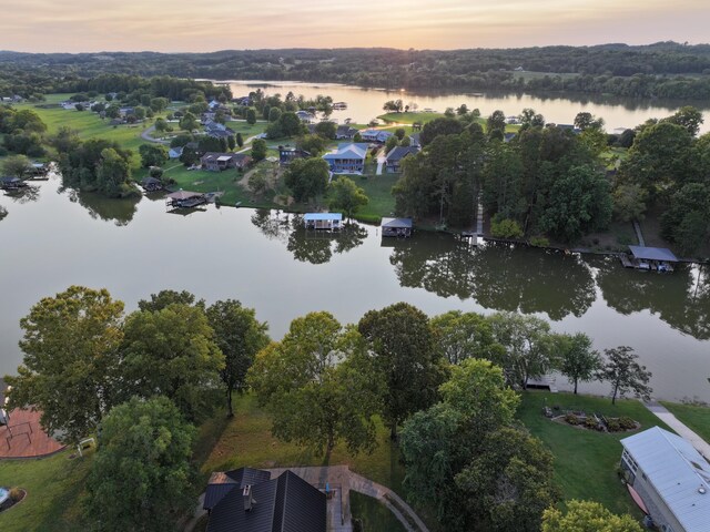 aerial view at dusk featuring a water view