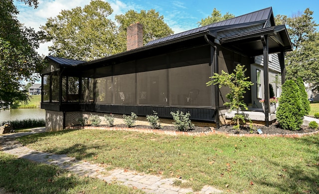 view of home's exterior featuring a yard and a sunroom