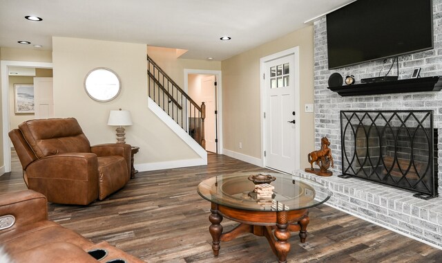 living room with a fireplace and dark hardwood / wood-style flooring