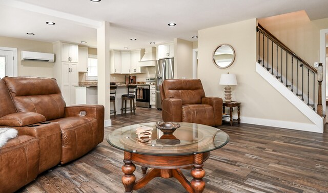 living room with a wall mounted AC and dark hardwood / wood-style floors