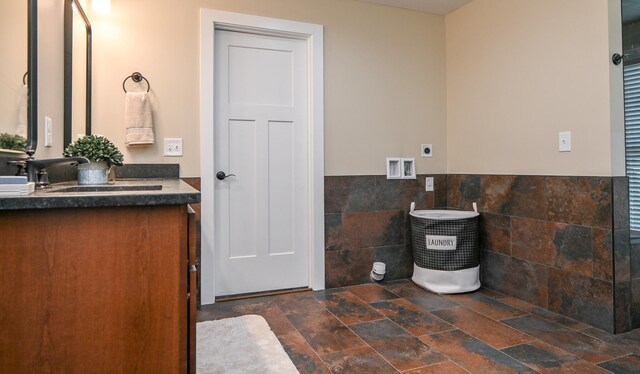 bathroom with vanity and tile walls