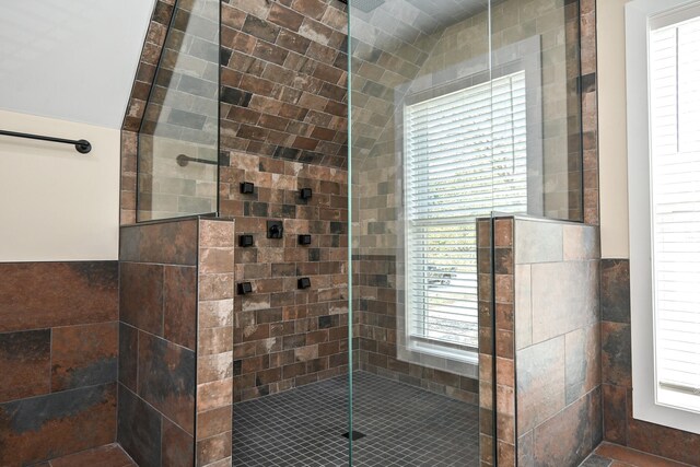 bathroom featuring plenty of natural light, tile walls, and tiled shower