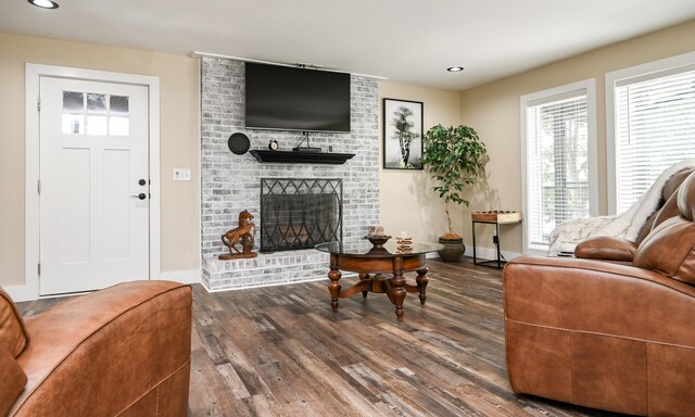 living room featuring dark hardwood / wood-style flooring and a brick fireplace