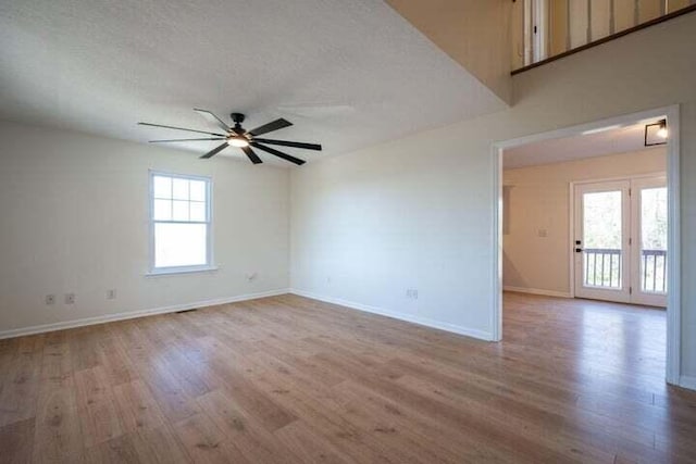 unfurnished room featuring ceiling fan, a textured ceiling, wood finished floors, and baseboards