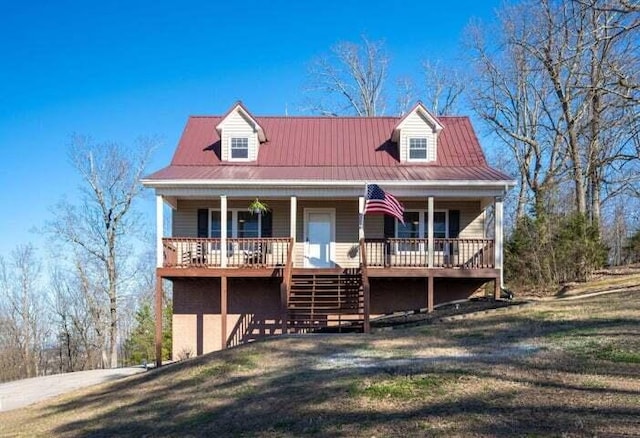 cape cod house with a porch, metal roof, a front lawn, and stairs