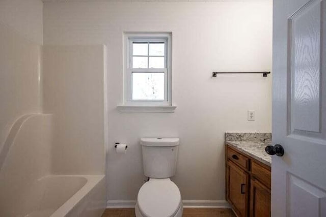 full bath with toilet, baseboards, and vanity