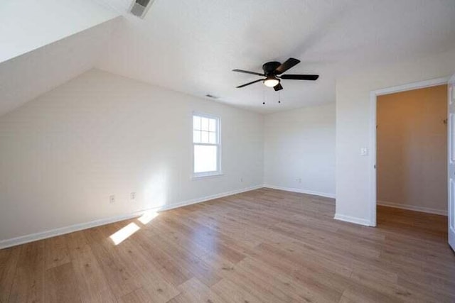 interior space featuring a ceiling fan, visible vents, baseboards, and wood finished floors